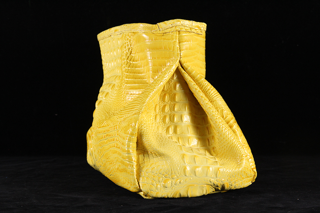 A yellow leather bag with no straps